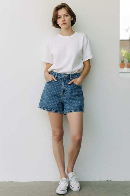 Person wearing a white t-shirt and blue denim shorts against a plain background