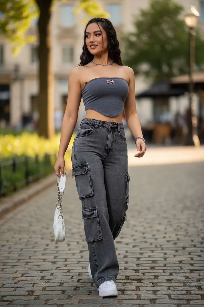 Woman walking on a street wearing a gray crop top and cargo pants.